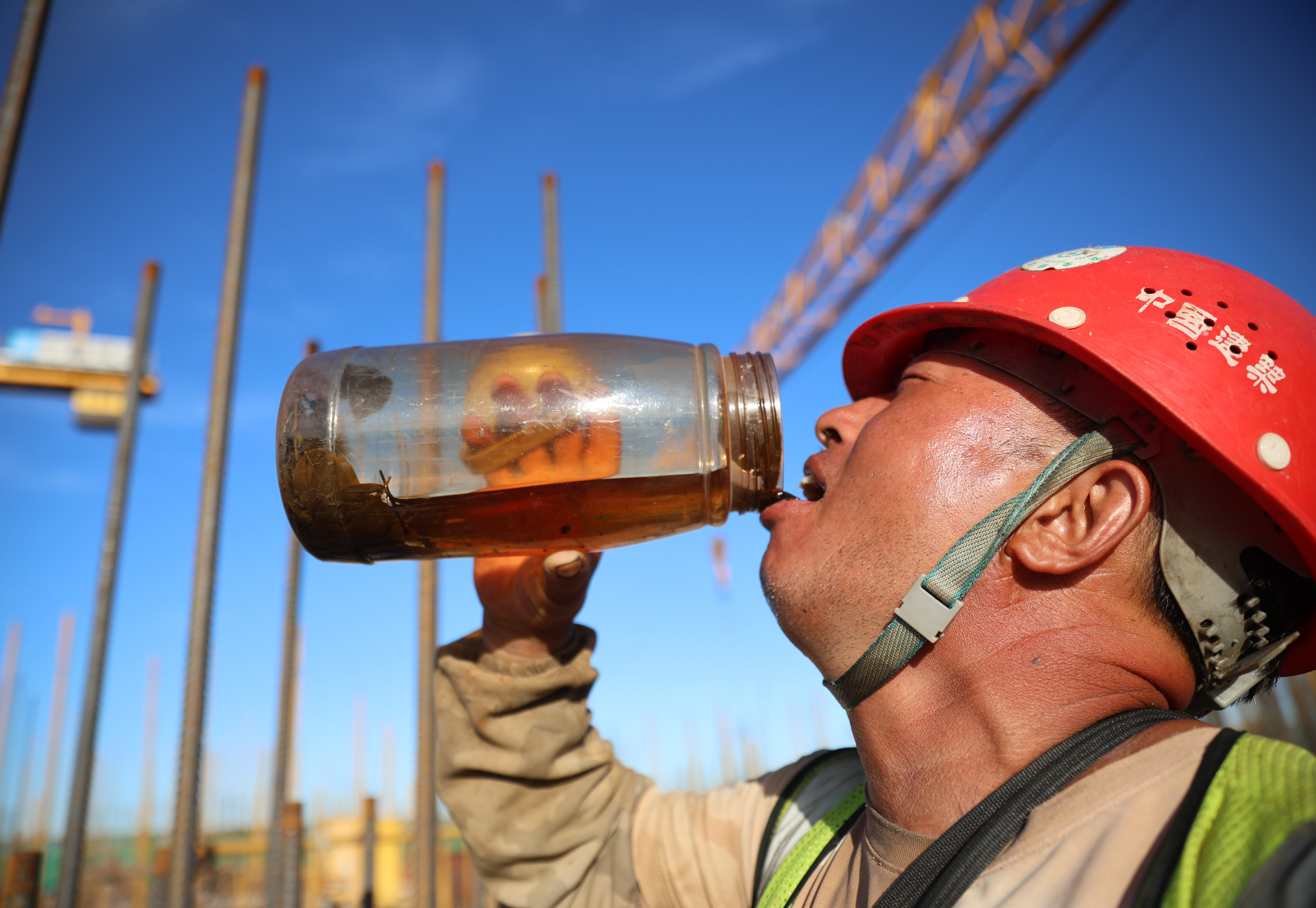 烈日下，工人正大口大口的喝着水。