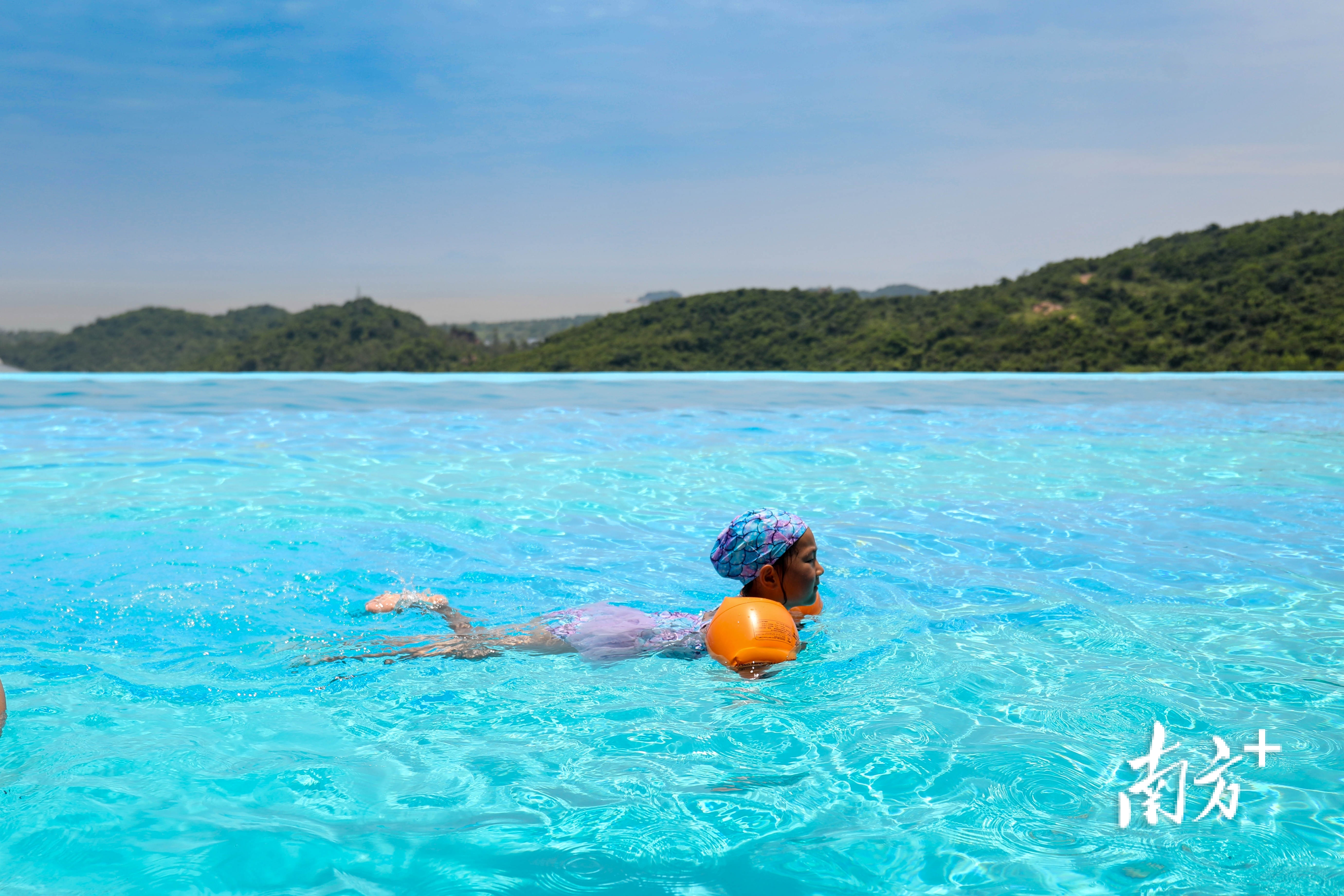 儿童在无边际泳池畅游。 