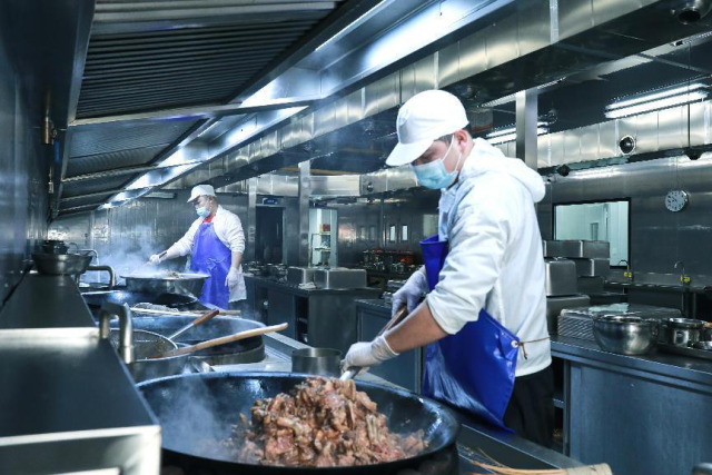 晁谷农业员工在厨房炒制菜品。