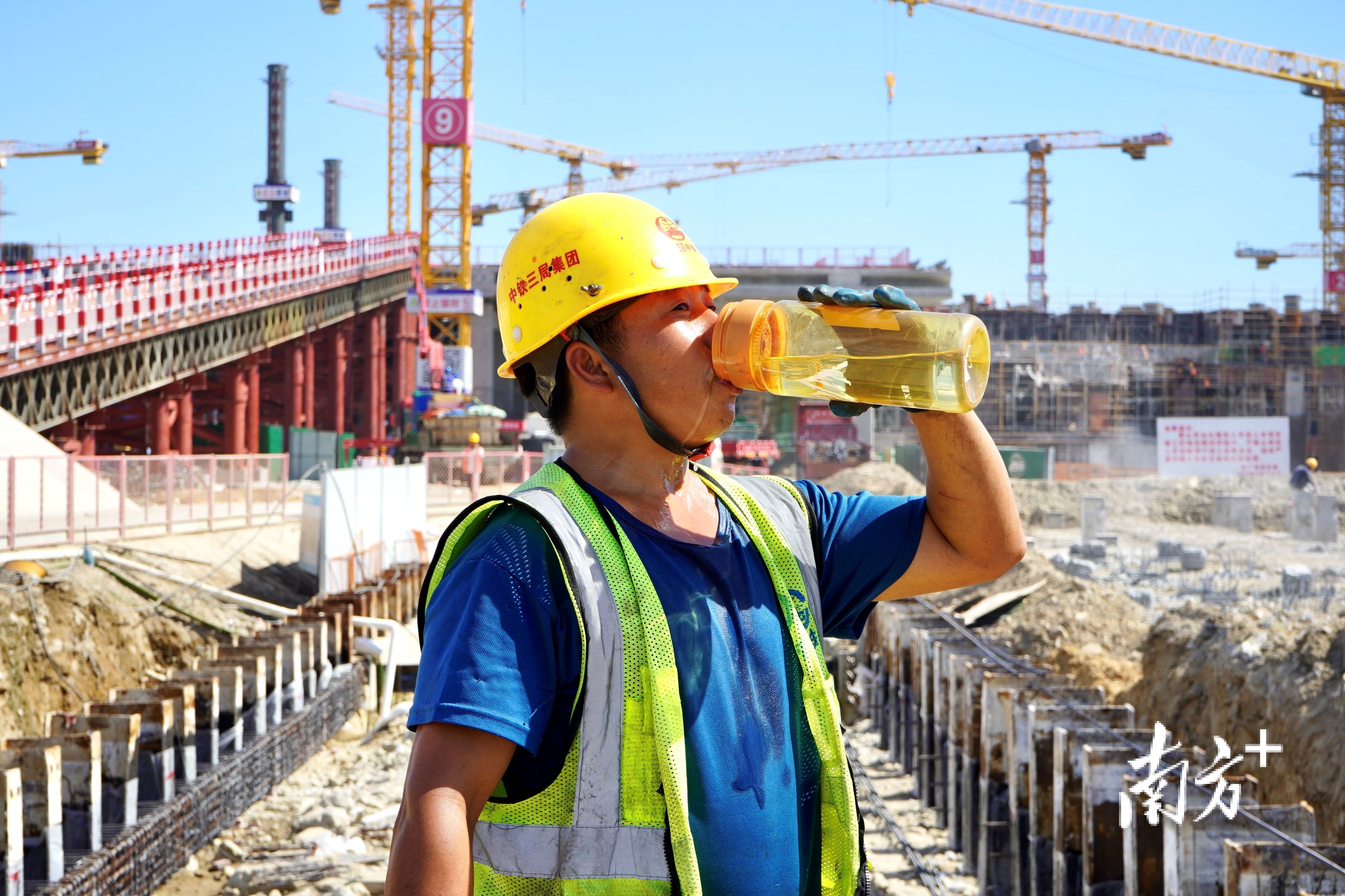 户外工地上，工人大口喝水。杨立轩 摄