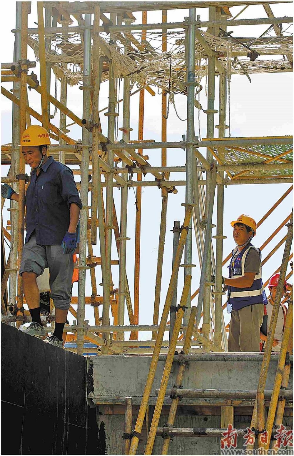 工人在钢架林立的建筑上施工。谢嘉龙 摄