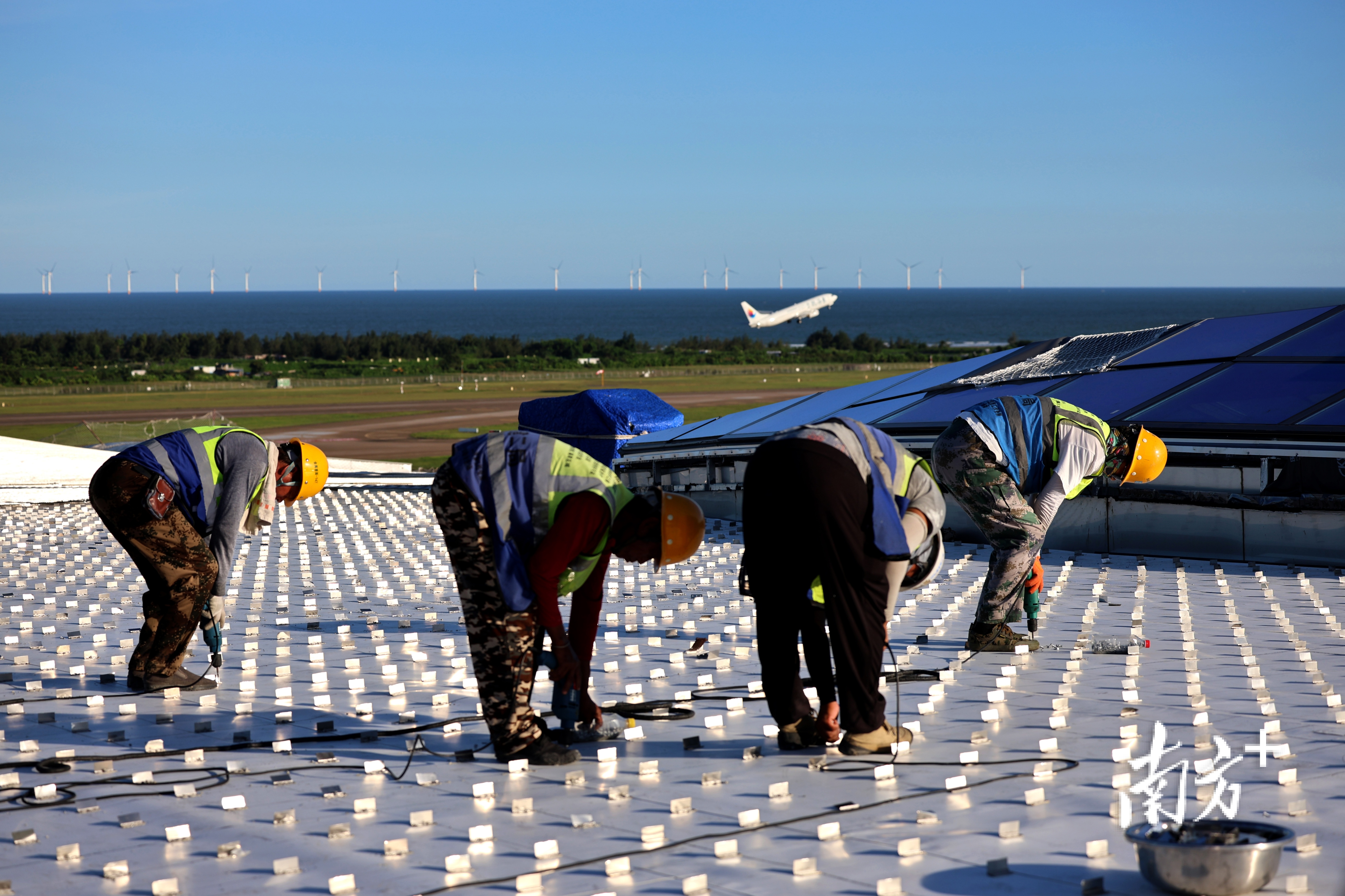 珠海机场改扩建工程项目的建设现场,工人们背朝烈日,为一段段防水材料打上牢固的钉子。 珠海机场改扩建工程项目的建设现场,工人们背朝烈日,为一段段防水材料打上牢固的钉子。
