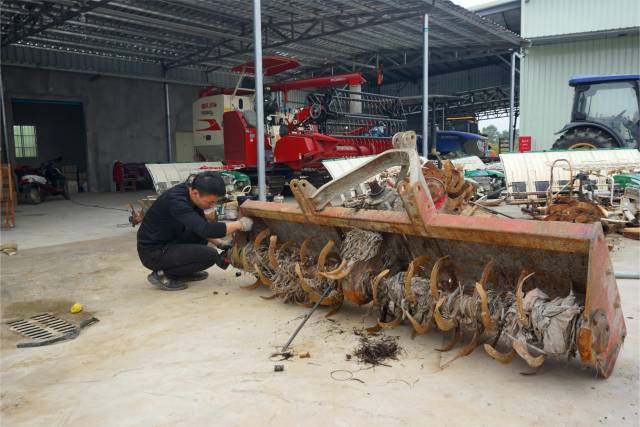 合作社里，维修人员正在保养农机。