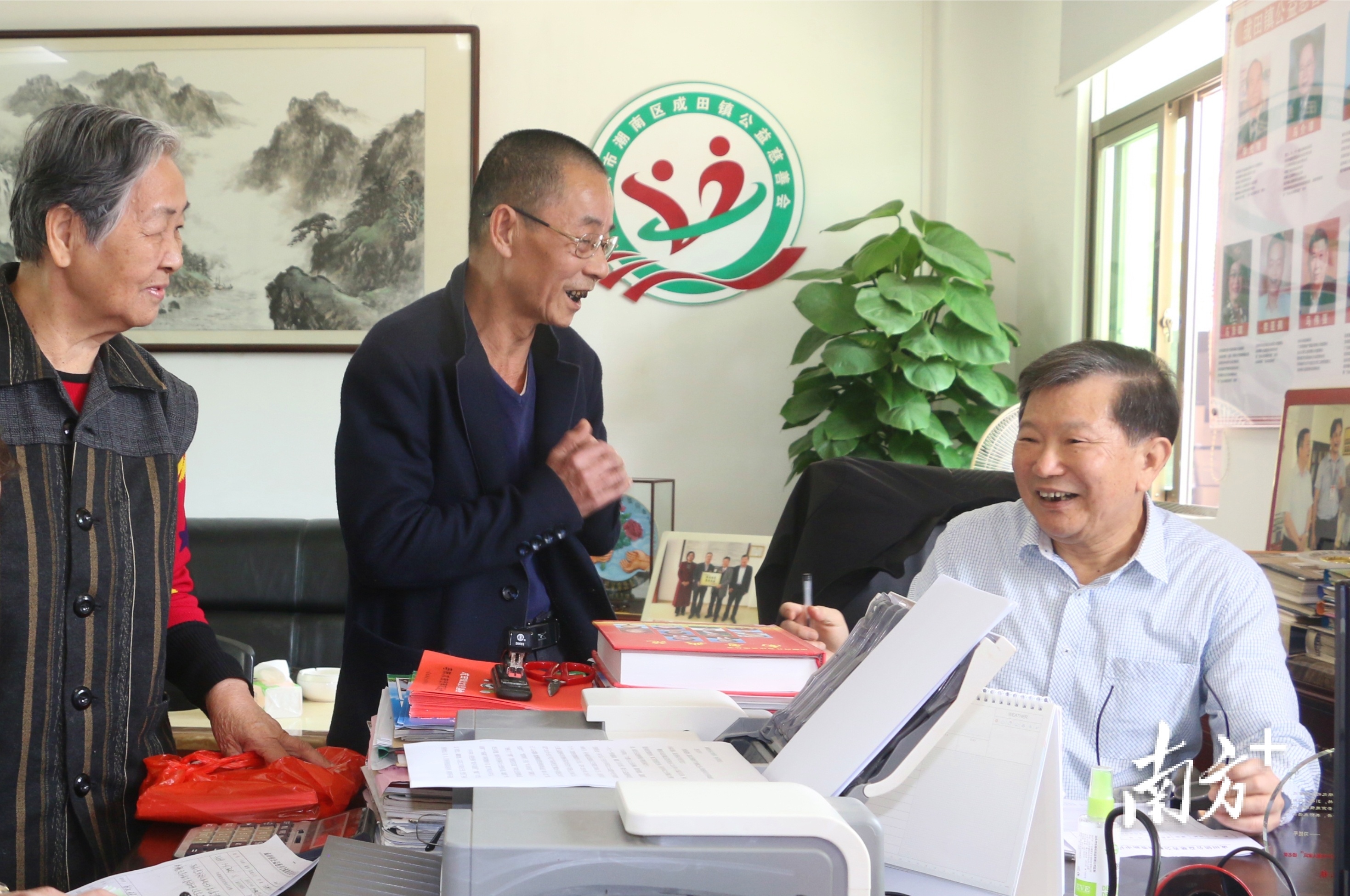 在成田镇公益慈善会，年过七旬的马灿镇（右）依然奔走在公益慈善一线。