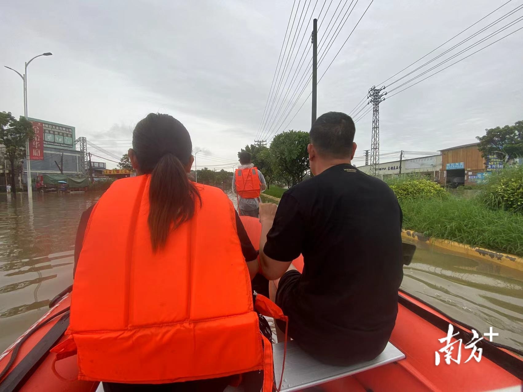 金利镇政府工作人员陈杰堂跳入水中拖行冲锋艇。