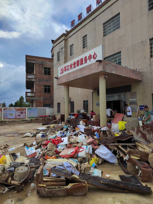 环江村干部和驻村工作组成员一起清理村委大楼。
