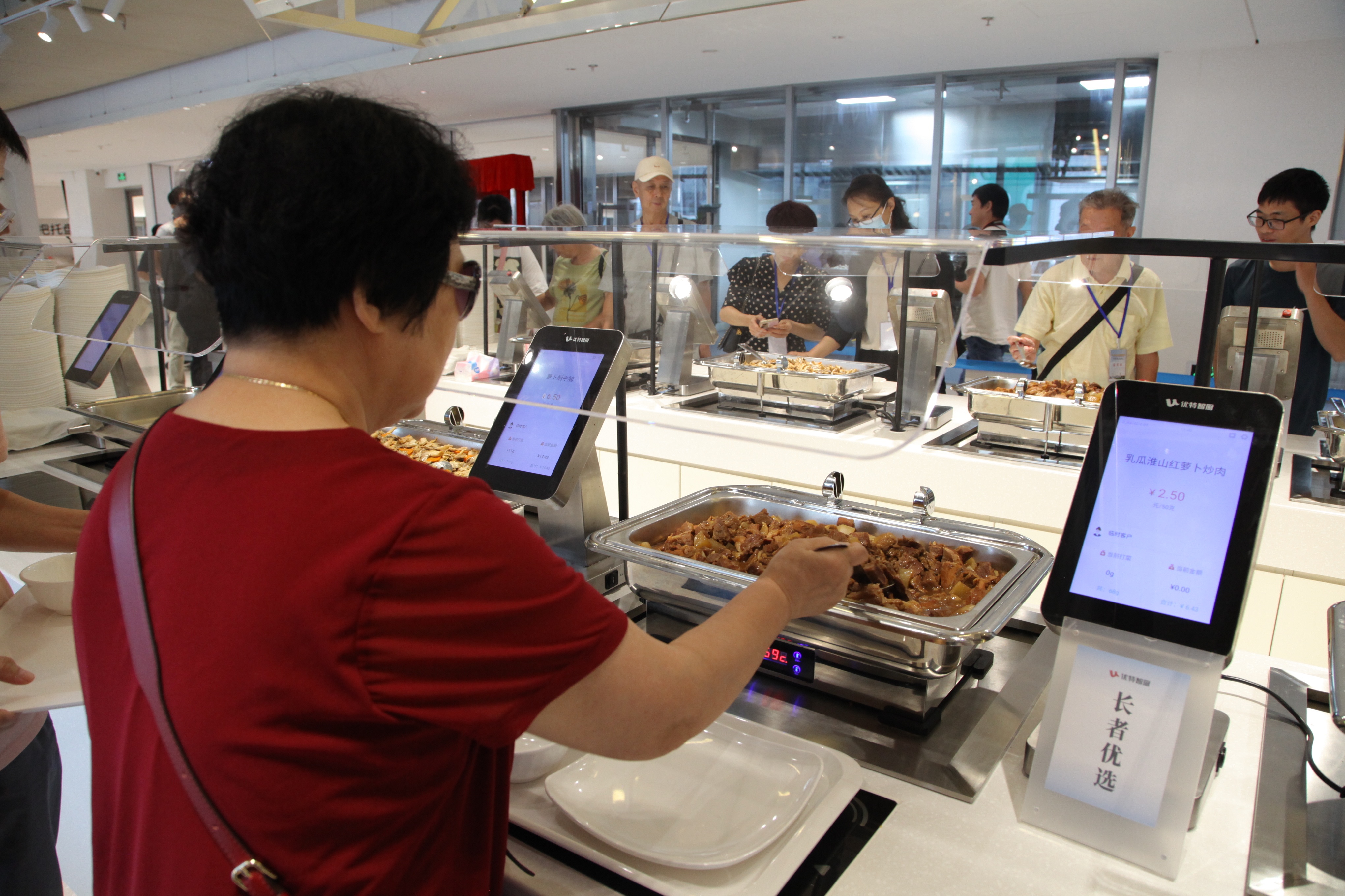优特社区餐厅中,长者们正在挑选餐食。梁芷曼 摄 优特社区餐厅中,长者们正在挑选餐食。梁芷曼 摄