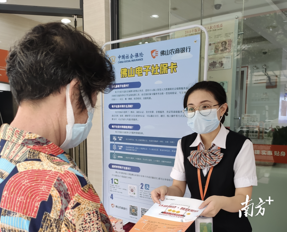 佛山农商银行工作人员向群众宣传介绍电子社保卡。