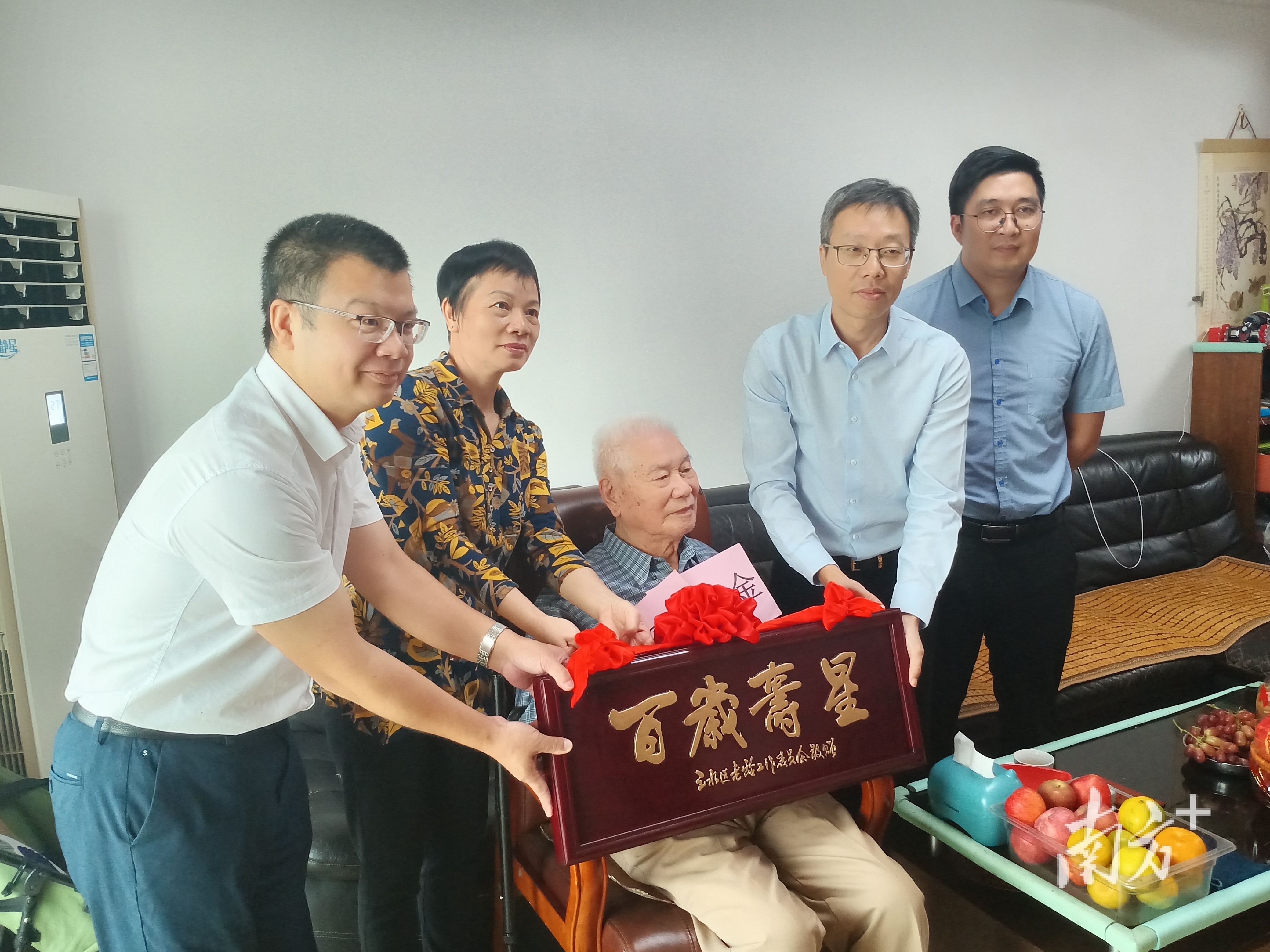三水区副区长林均恒带队看望西南街道新晋百岁老人潘育化(中坐者),并为他送上“百岁寿星”牌匾。 南方+ 魏英 拍摄 三水区副区长林均恒带队看望西南街道新晋百岁老人潘育化(中坐者),并为他送上“百岁寿星”牌匾。 南方+ 魏英 拍摄