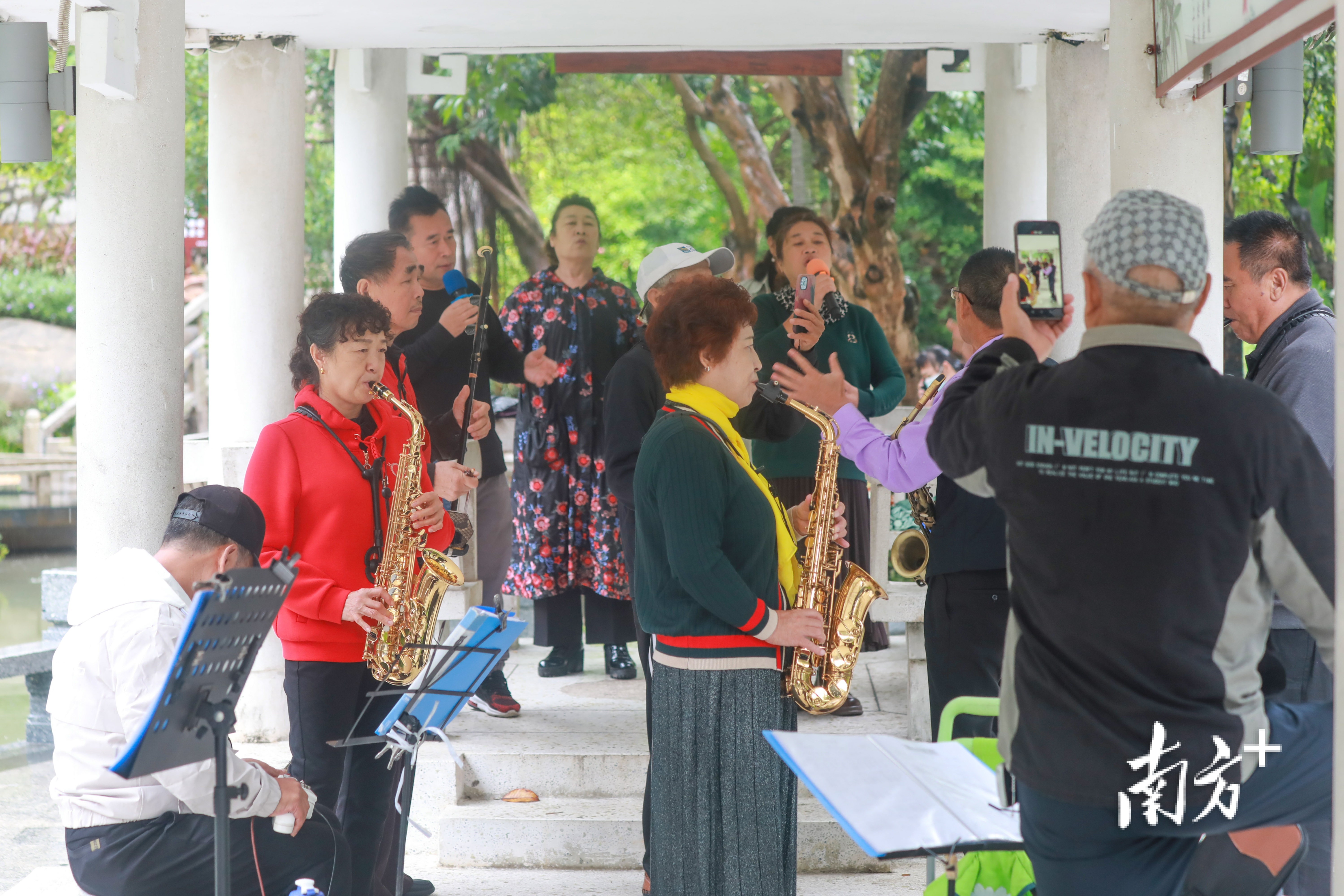 公园亭子里，老人们自发组成的“乐队”一起合奏合唱，乐享晚年   