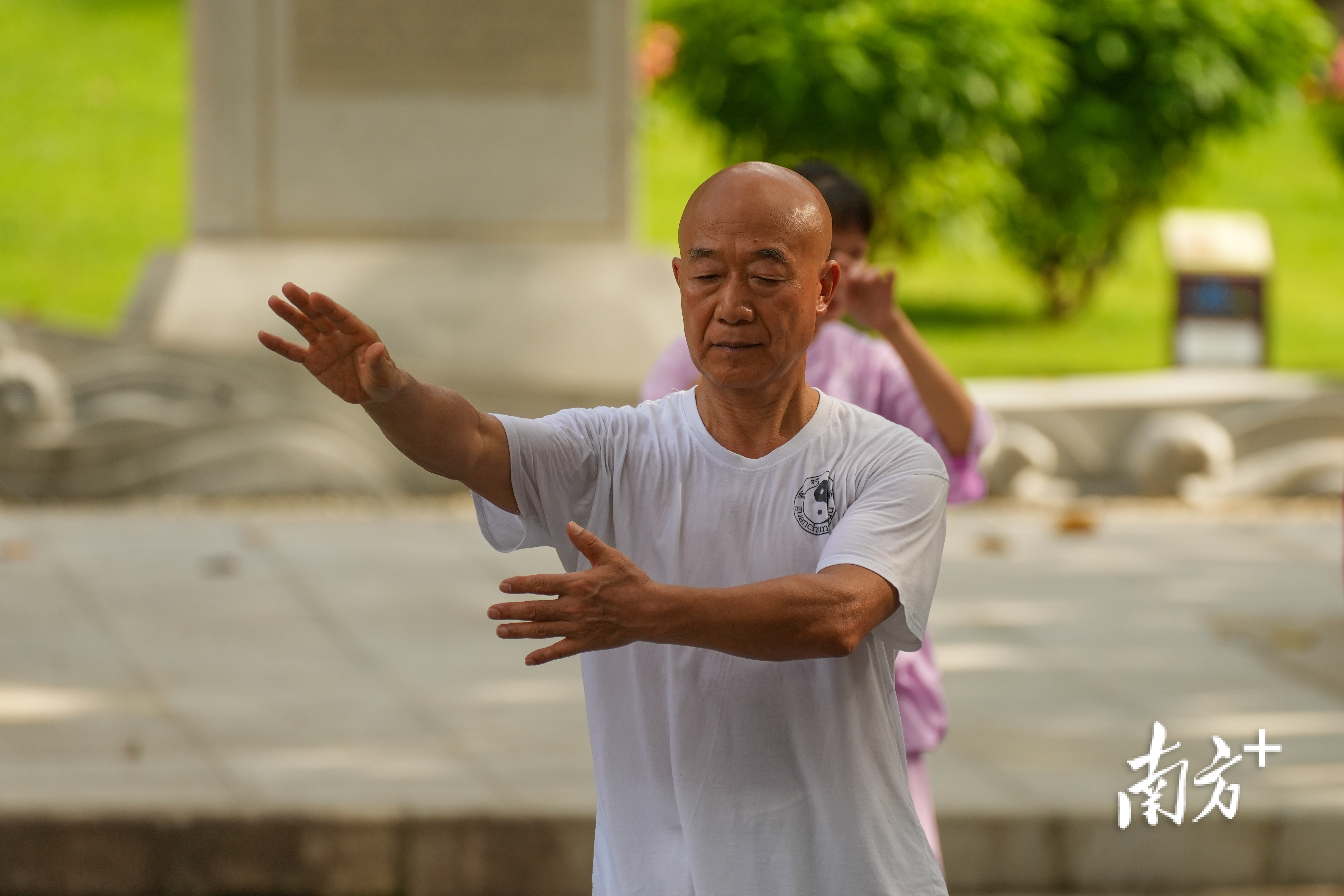 老人在公园里打太极拳。  