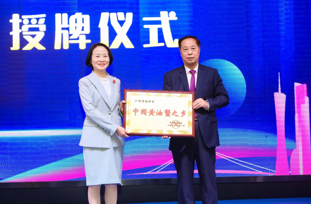 中国渔业协会会长赵兴武（右）向广州市南沙区副区长刘小潼颁发“中国黄油蟹之乡”牌匾。