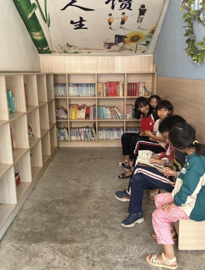 课间在楼梯图书角阅读的学生。