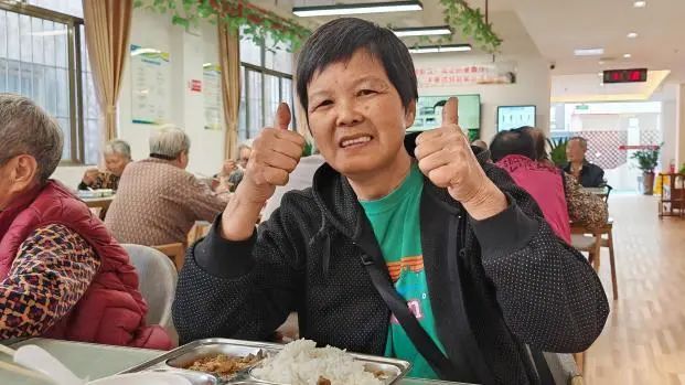 图为王姨为饭堂里的服务点赞。 图为王姨为饭堂里的服务点赞。