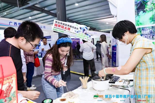 游客在展位上品尝猪肉。