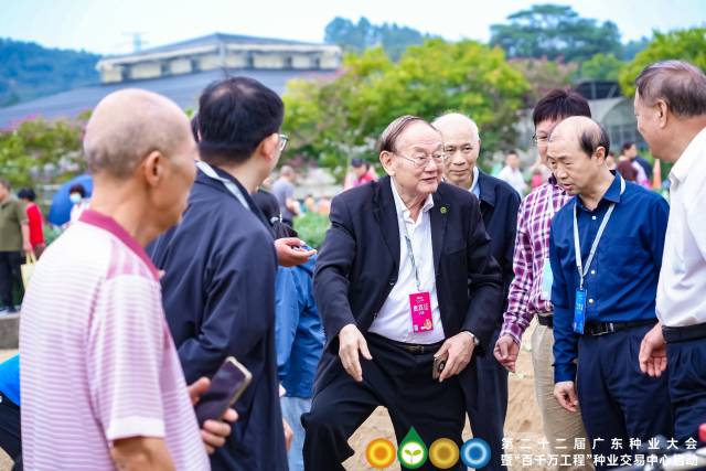 中国工程院院士罗锡文（左三）在田间指导农机自动作业，为群众描绘智慧农业未来。