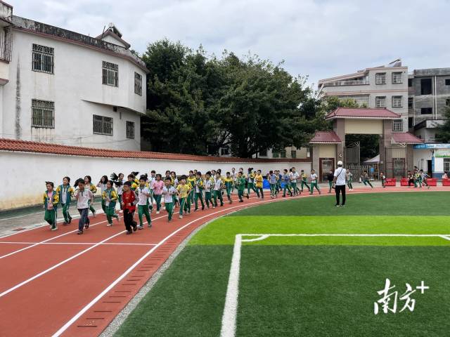 梅林镇中心小学学生在崭新的运动场上奔跑。受访者供图