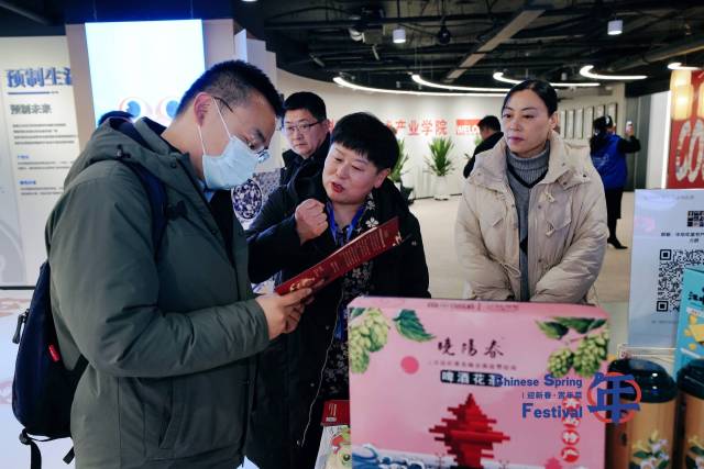 现场展示展销的“年菜”产品吸引嘉宾驻足交流。