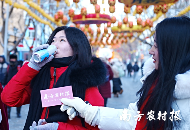 往来市民、游客品尝荔小吉旗下产品海盐荔枝果汁饮料。