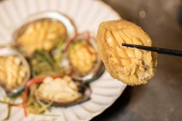 鲍鱼做为年夜饭压轴菜，有“一夜暴富”的寓意。摄影/吴秒衡