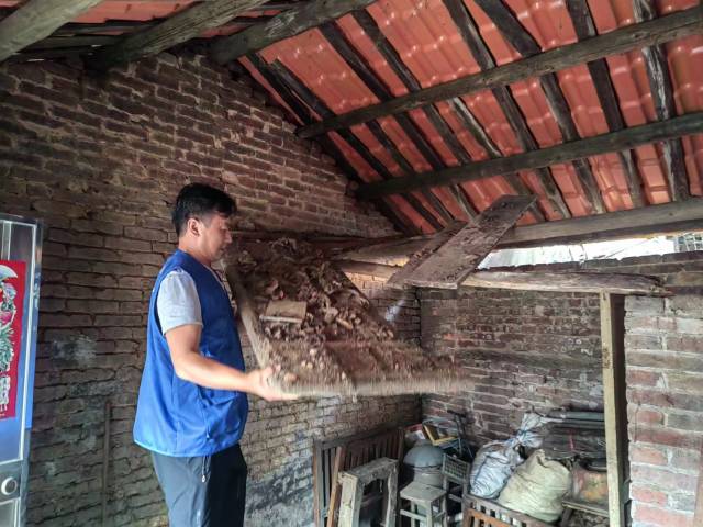 乡村助老员朱海平帮老人清理房梁上的木板。受访者供图