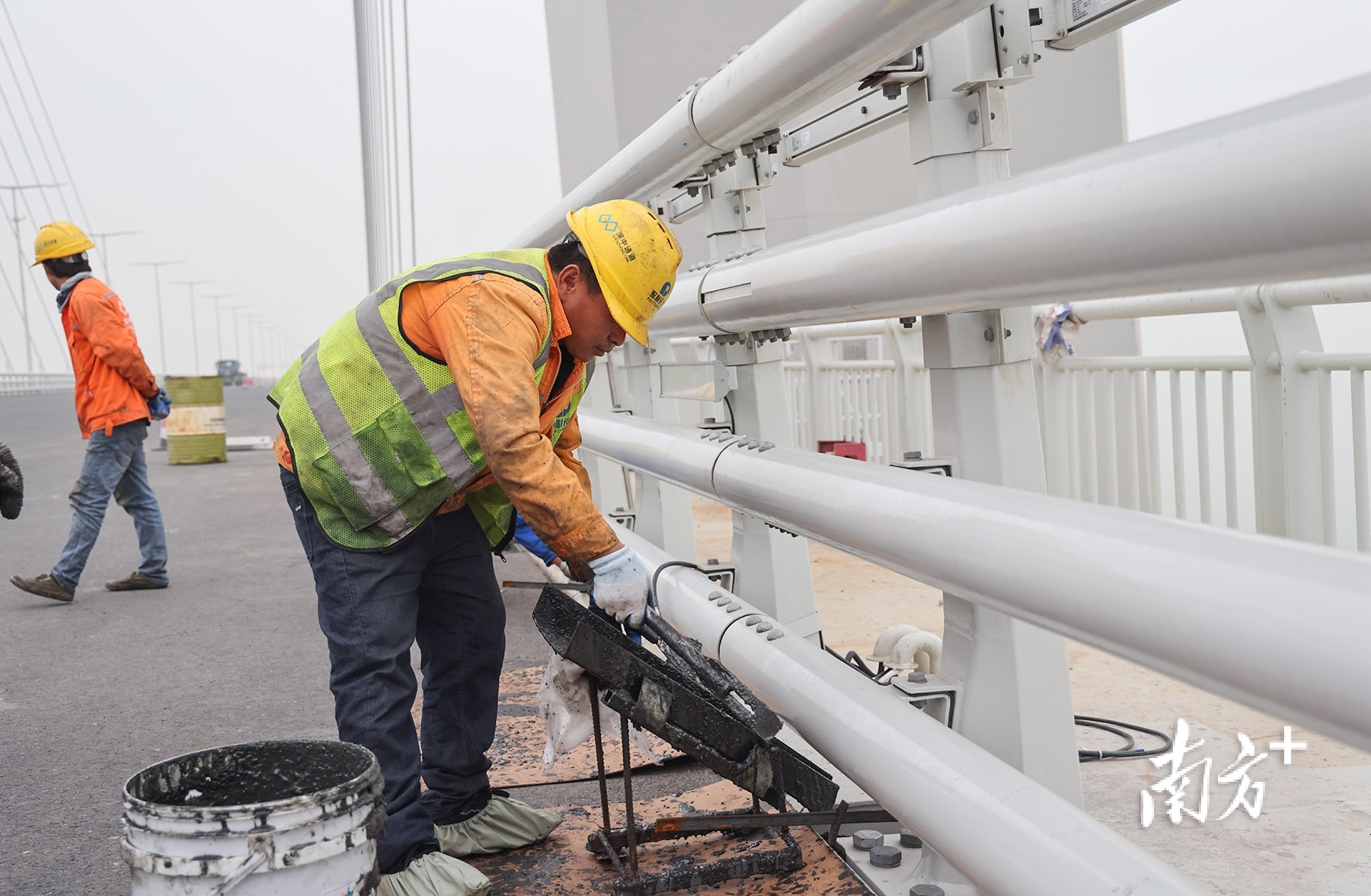 深中通道中山大桥上,工人在进行弹性混凝土填缝施工。 南方+ 叶志文 拍摄 深中通道中山大桥上,工人在进行弹性混凝土填缝施工。 南方+ 叶志文 拍摄