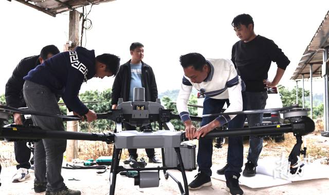 王超和合作伙伴在田间地头组装新到的无人机。 