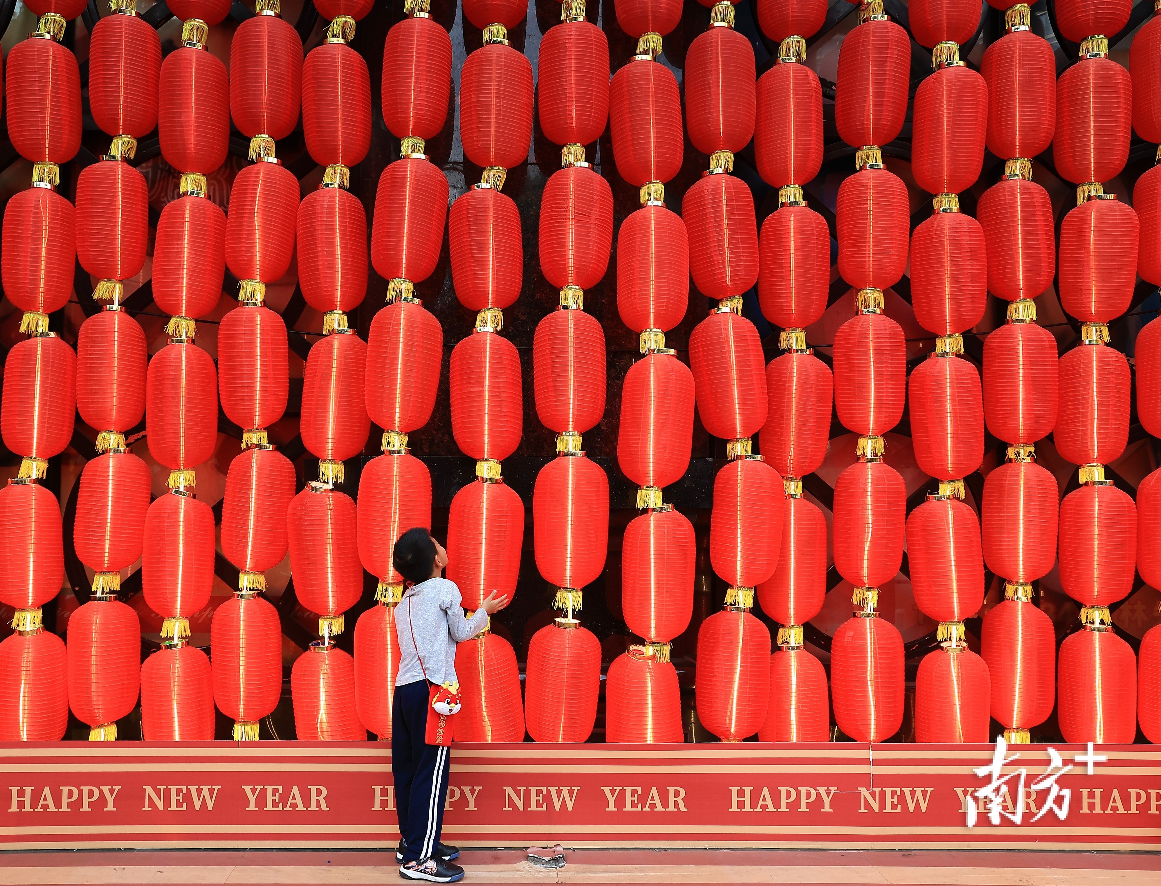 2月2日,广州市越秀区一商场外挂满一串串红灯笼,吸引一名小朋友观看。孙惠红 摄 2月2日,广州市越秀区一商场外挂满一串串红灯笼,吸引一名小朋友观看。孙惠红 摄