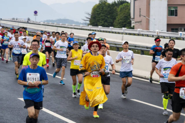 “龙袍”装扮的“皇帝”跑过洲心大桥。3月17日，2019时代中国清远马拉松赛开跑。 资料图