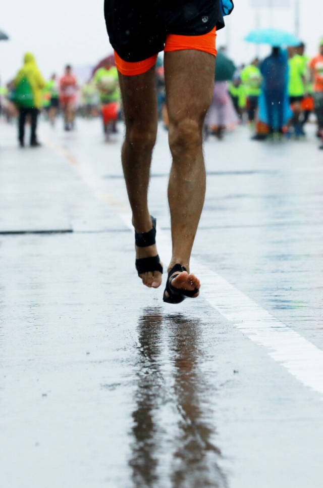 2017年3月19日，一位赤脚跑者雨中赛跑。资料图