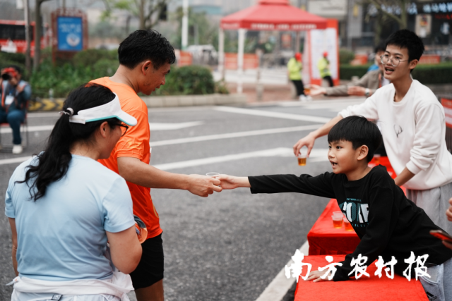 参赛者接过市民手中的英德红茶。 参赛者接过市民手中的英德红茶。